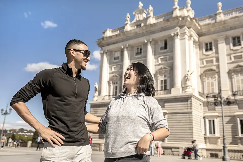 两个学生在马德里皇宫附近笑着散步.